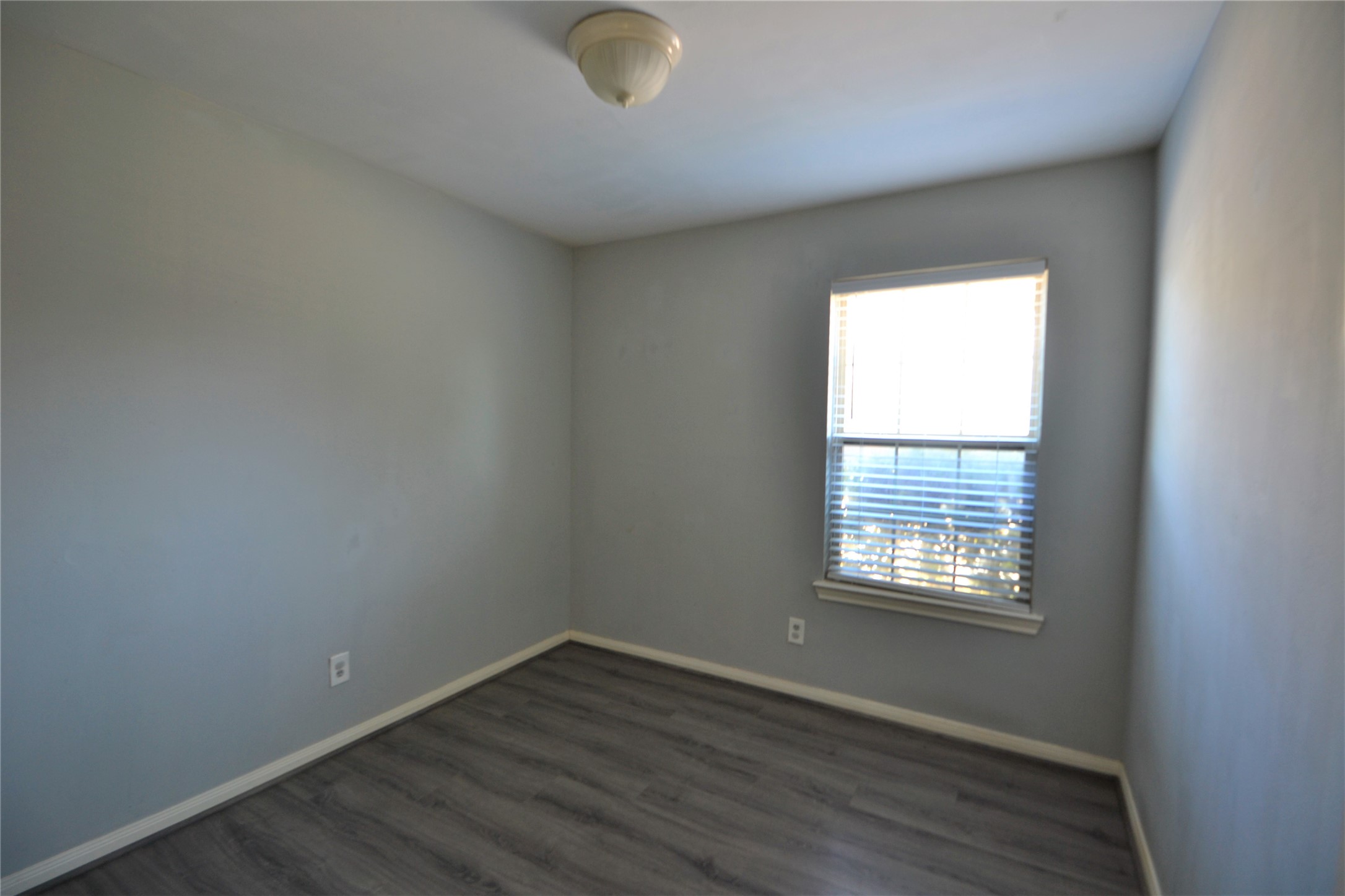304 Dell Court, Unit 7 Houston, TX 77009 - Photo 28 of 36 an empty room with wooden floor and windows