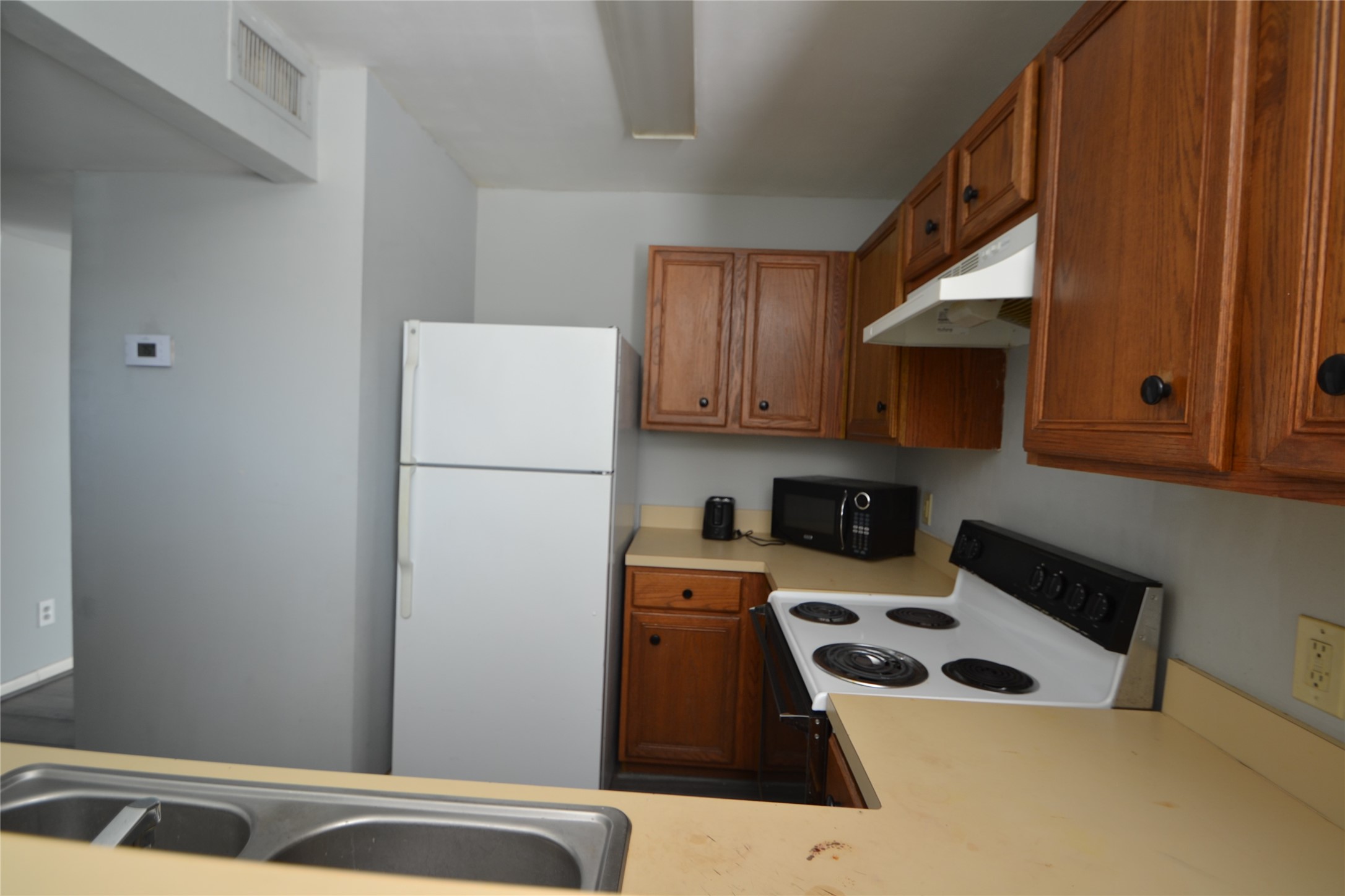304 Dell Court, Unit 7 Houston, TX 77009 - Photo 33 of 36 a kitchen with a refrigerator a stove a sink and cabinets