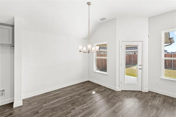 a view of a room with wooden floor and windows