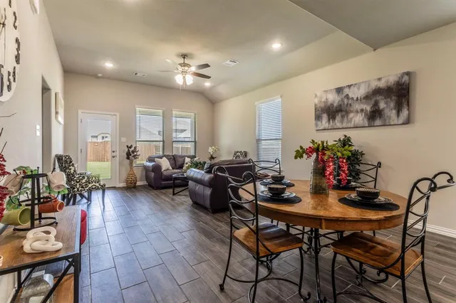 a living room with furniture and a dining table with kitchen view