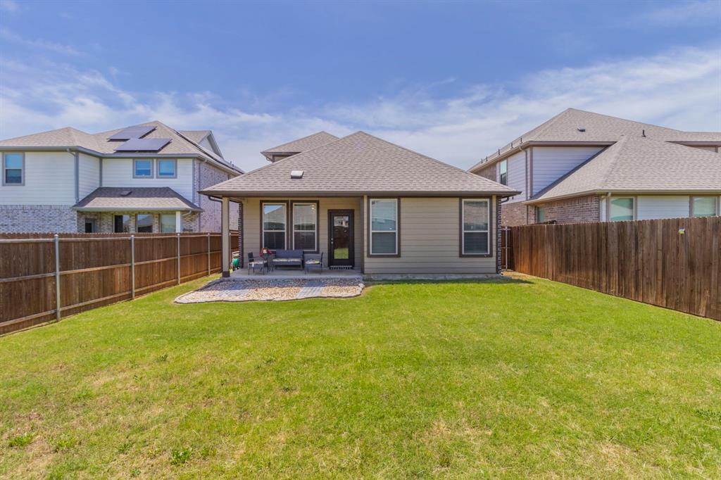 626 Ruthye Lane Pilot Point, TX 76258 - Photo 23 of 28 Back of property with a patio area, a fenced backyard, and a shingled roof