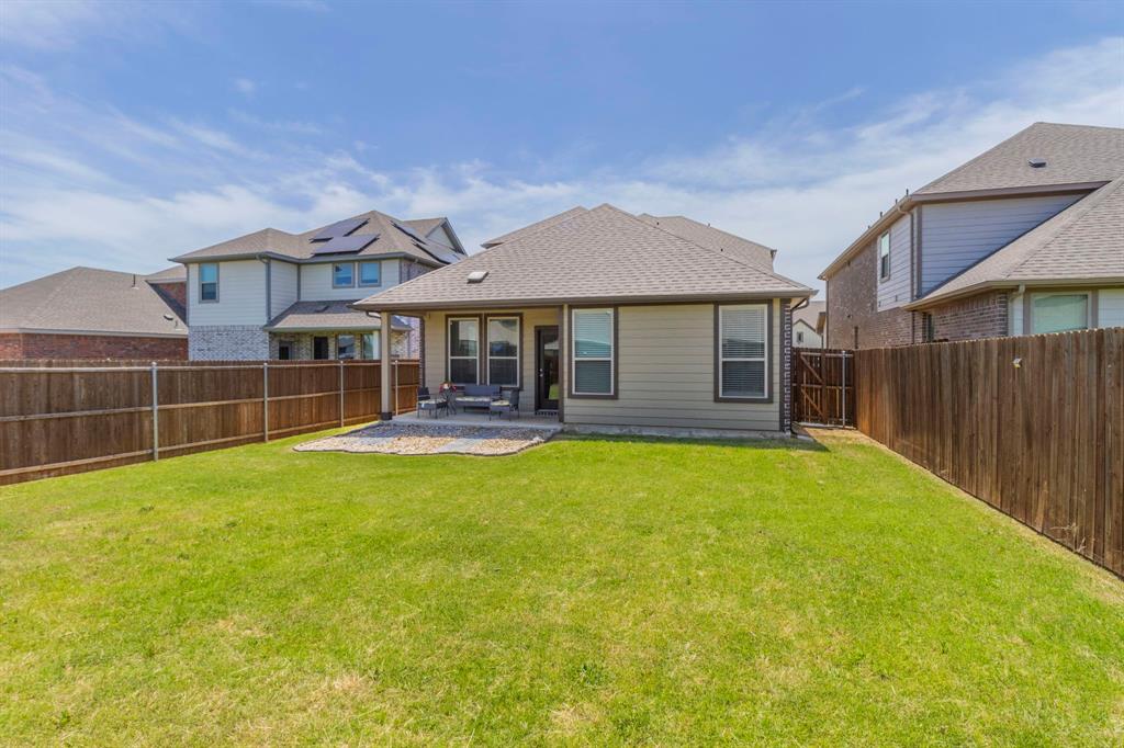 626 Ruthye Lane Pilot Point, TX 76258 - Photo 25 of 28 Back of house with a patio, a fenced backyard, and roof with shingles
