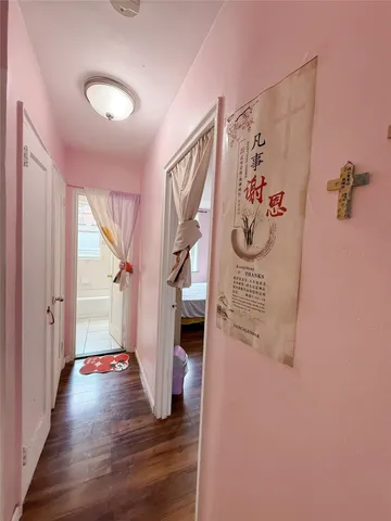a view of a hallway with wooden floor and stairs