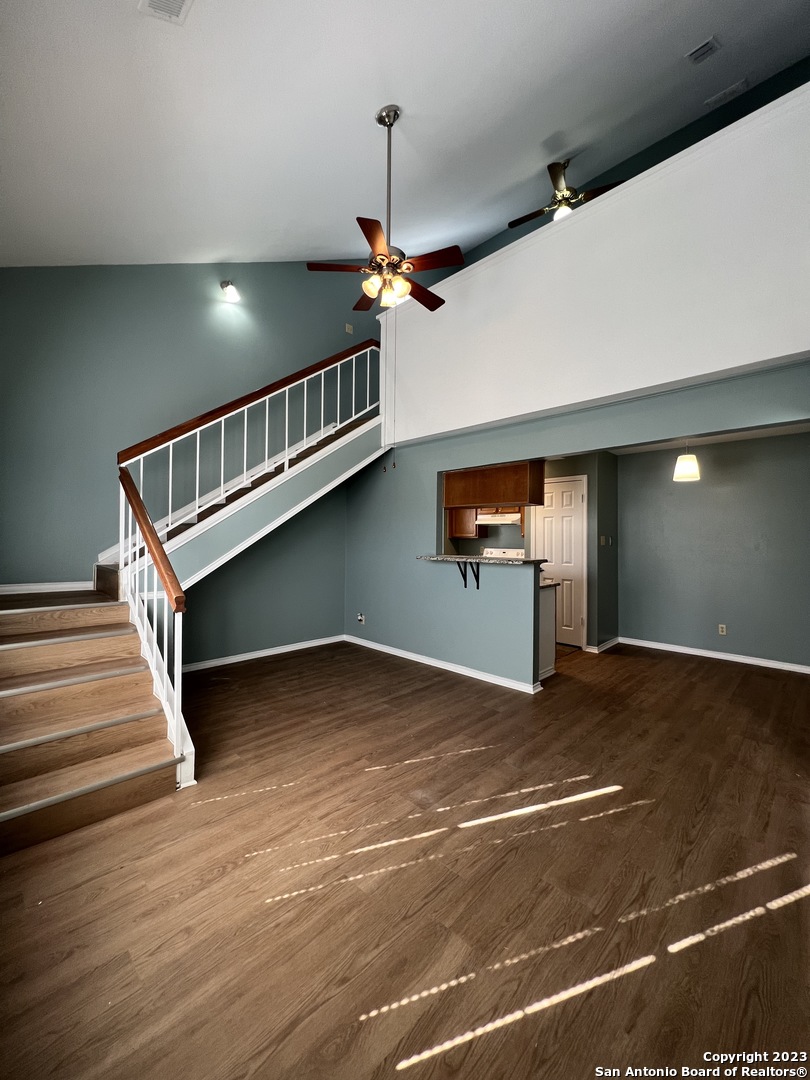 a view of empty room with stairs and wooden floor