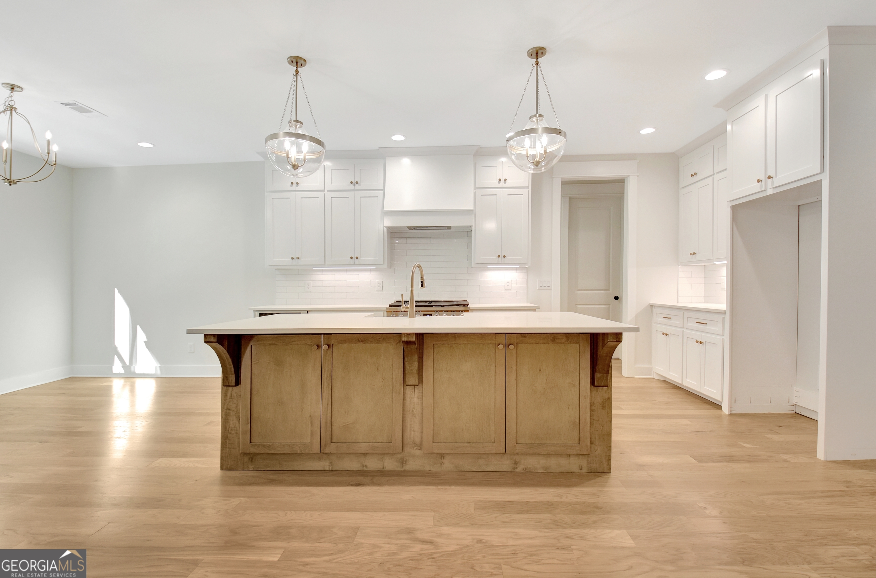 196 Bob Smith Road Sharpsburg, GA 30277 - Photo 20 of 68 a kitchen with kitchen island stainless steel appliances sink cabinets and wooden floor