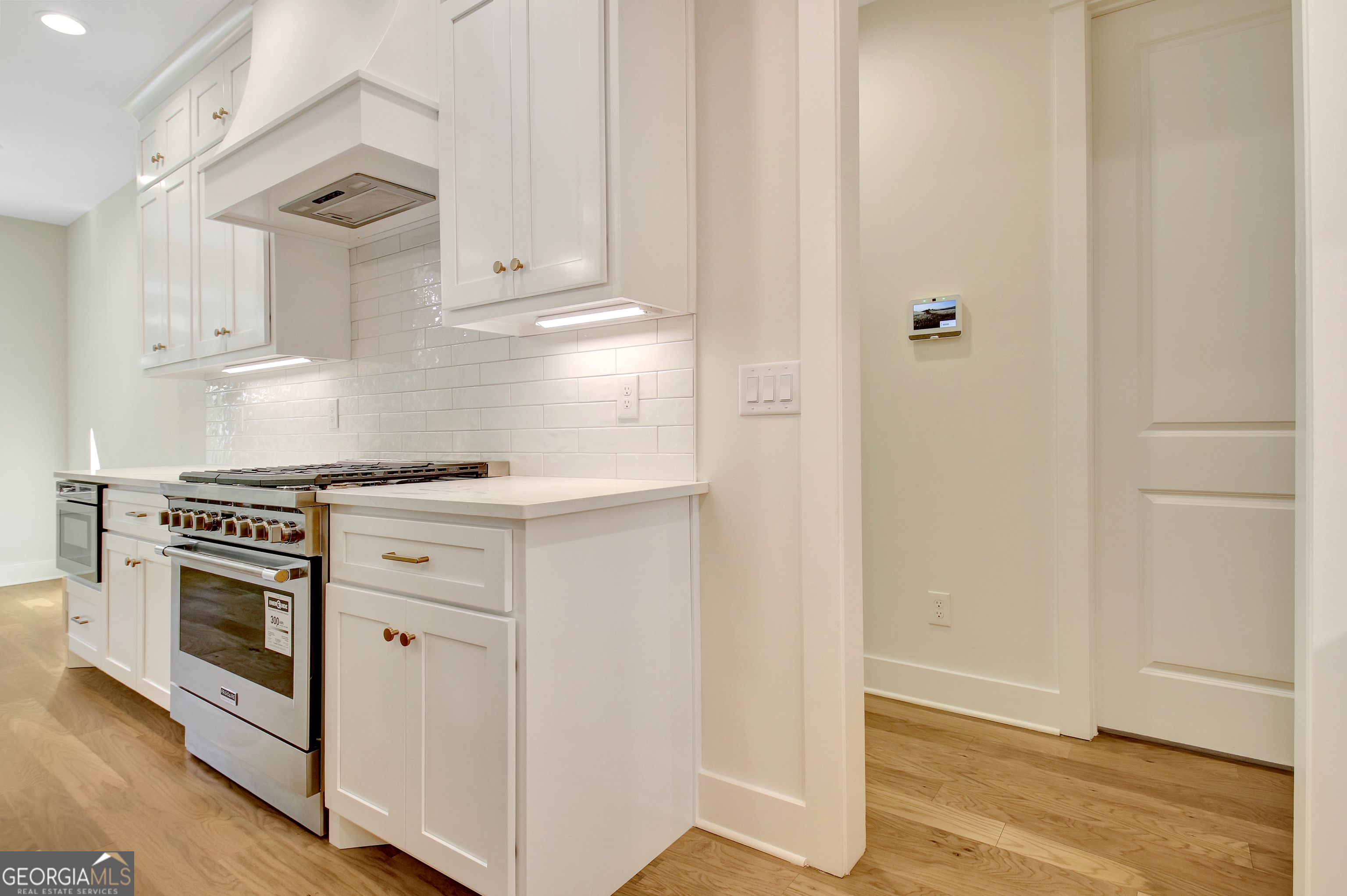 196 Bob Smith Road Sharpsburg, GA 30277 - Photo 23 of 68 a kitchen with granite countertop white cabinets and white appliances