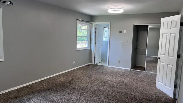 an empty room with windows and closet