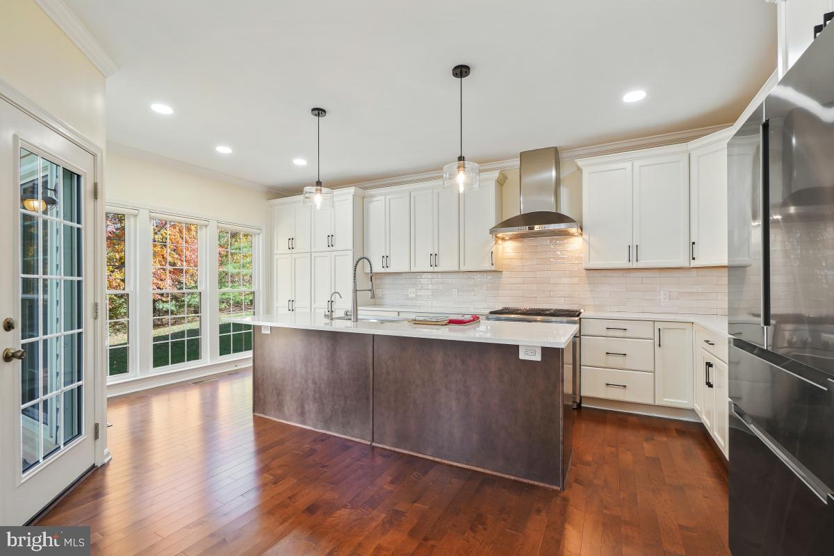 2442 Arctic Fox Way Reston, VA 20191 - Photo 14 of 58 a large kitchen with stainless steel appliances granite countertop a stove a sink dishwasher a refrigerator white cabinets and wooden floor