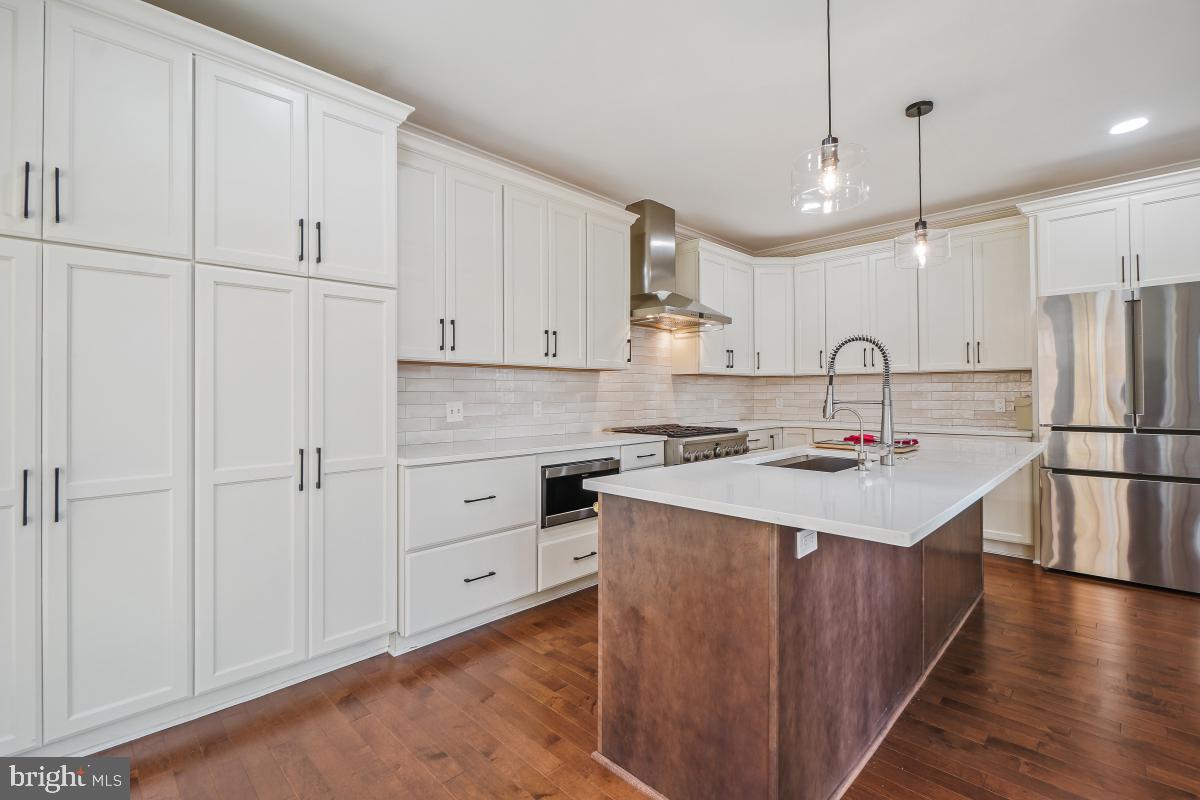 2442 Arctic Fox Way Reston, VA 20191 - Photo 18 of 58 a kitchen with a sink a stove a refrigerator and white cabinets