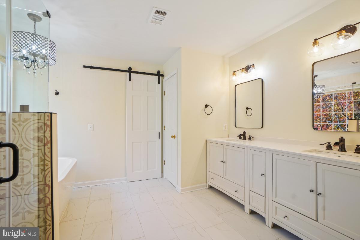 2442 Arctic Fox Way Reston, VA 20191 - Photo 32 of 58 a spacious bathroom with a double vanity sink a mirror and shower