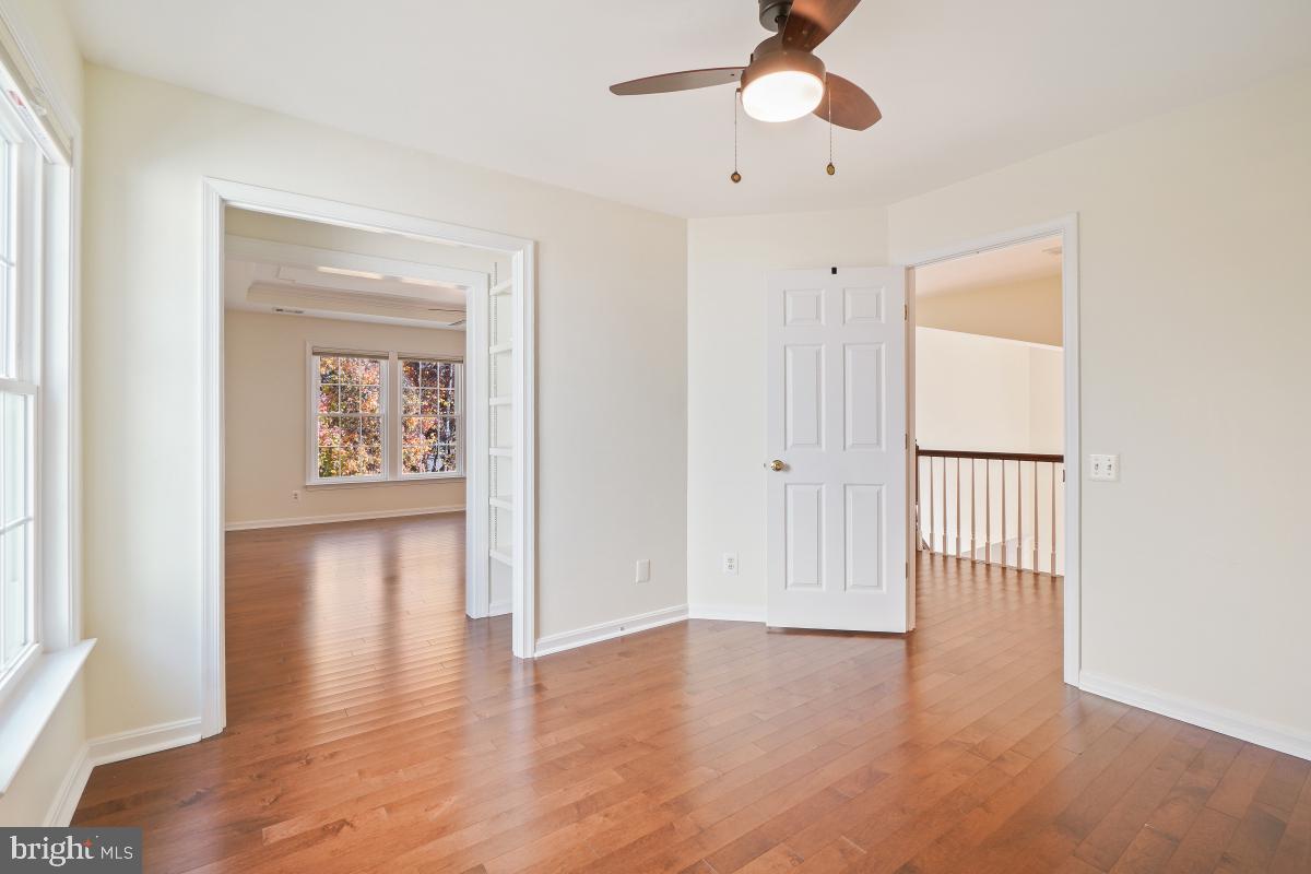 2442 Arctic Fox Way Reston, VA 20191 - Photo 35 of 58 an empty room with wooden floor chandelier fan and windows