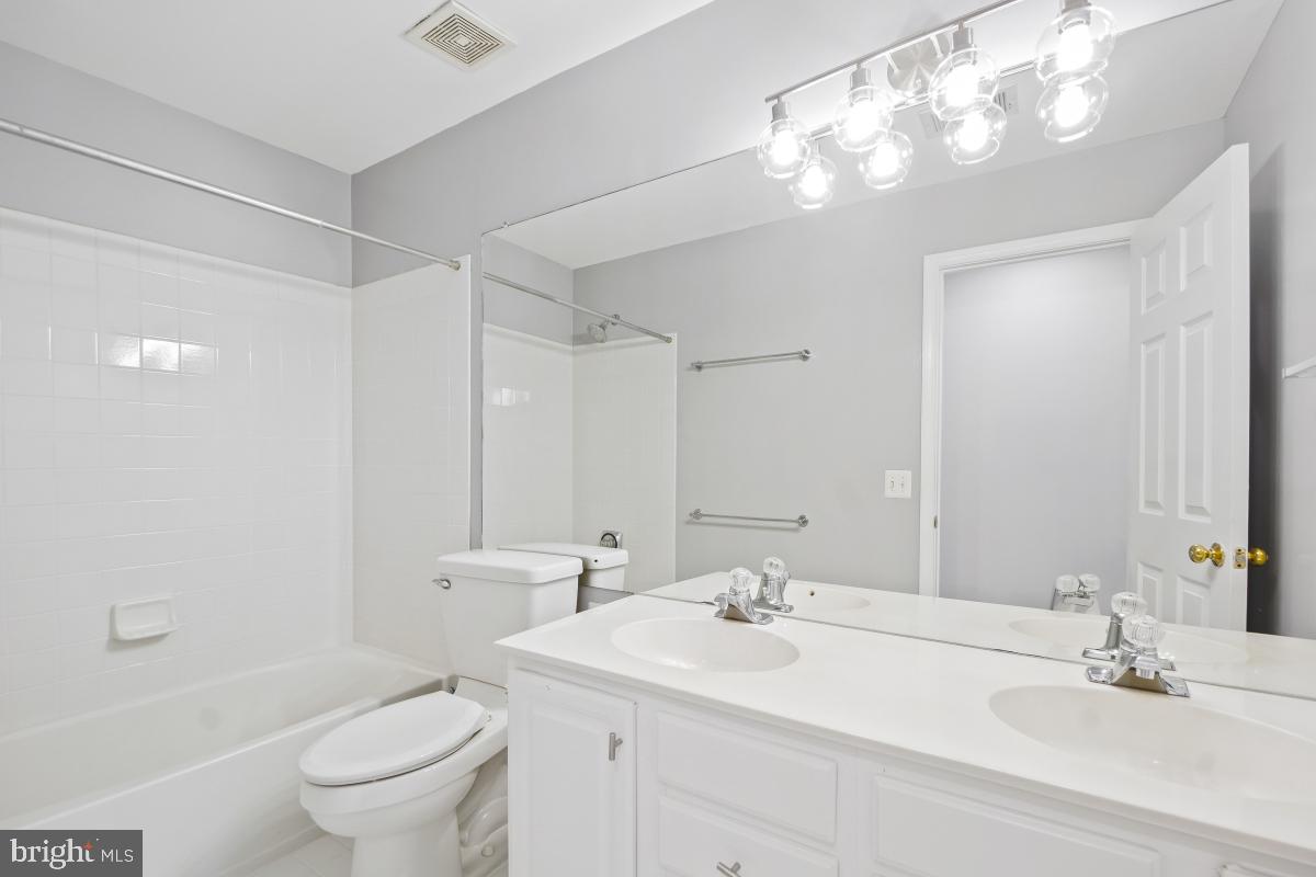 2442 Arctic Fox Way Reston, VA 20191 - Photo 38 of 58 a bathroom with a sink a toilet and a large mirror