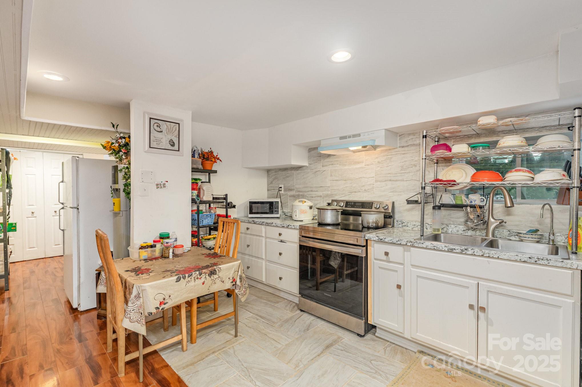 9716 Sunway Drive Mint Hill, NC 28227 - Photo 11 of 31 a kitchen with stainless steel appliances kitchen island granite countertop a refrigerator a sink dishwasher and white cabinets with wooden floor