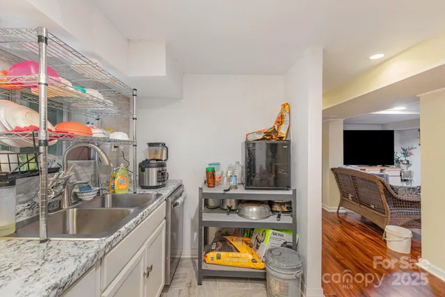 a kitchen with stainless steel appliances granite countertop a sink and a refrigerator