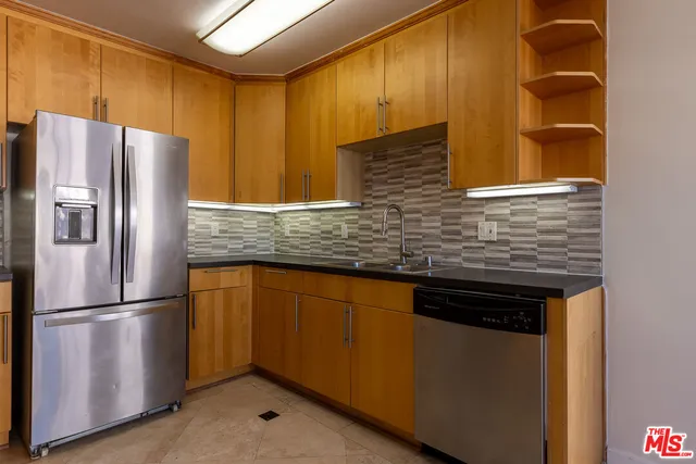 a kitchen with stainless steel appliances granite countertop a refrigerator and a sink