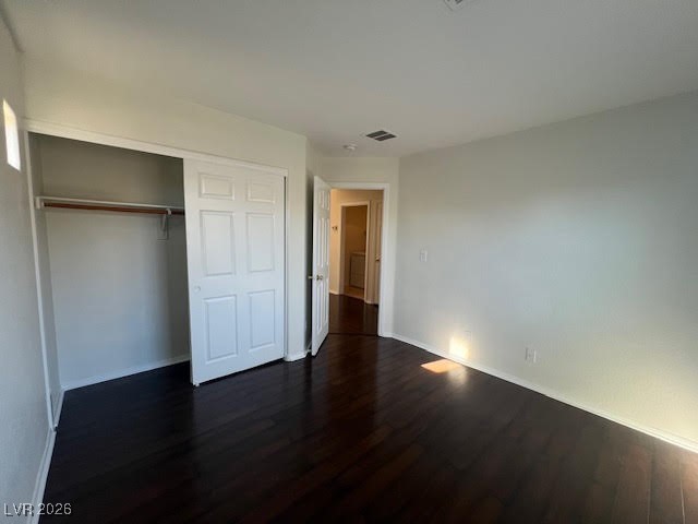 8229 Strawberry Spring Street Las Vegas, NV 89143 - Photo 17 of 40 Unfurnished bedroom featuring dark wood-style floors and a closet