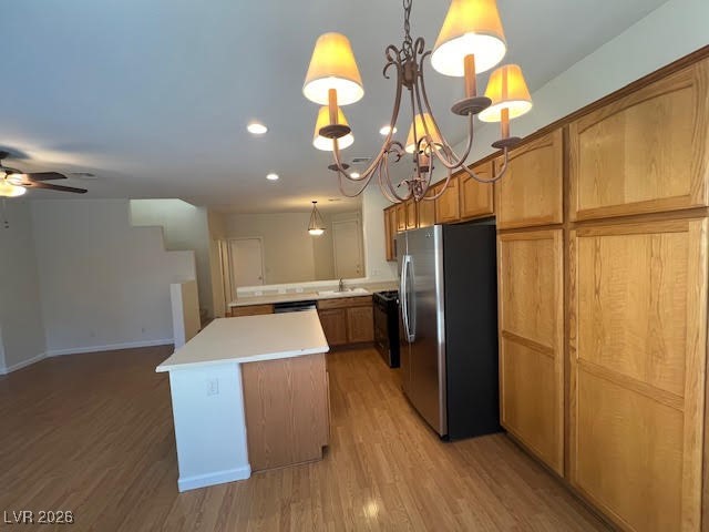 8229 Strawberry Spring Street Las Vegas, NV 89143 - Photo 8 of 40 Kitchen with freestanding refrigerator, light countertops, light wood-style flooring, a chandelier, and a kitchen island