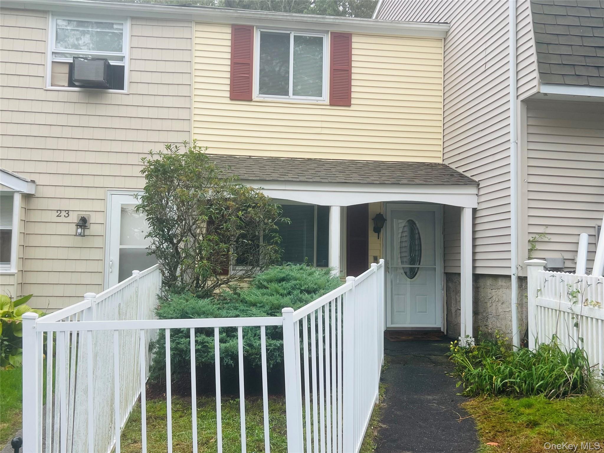 a view of a house with a yard and potted plants