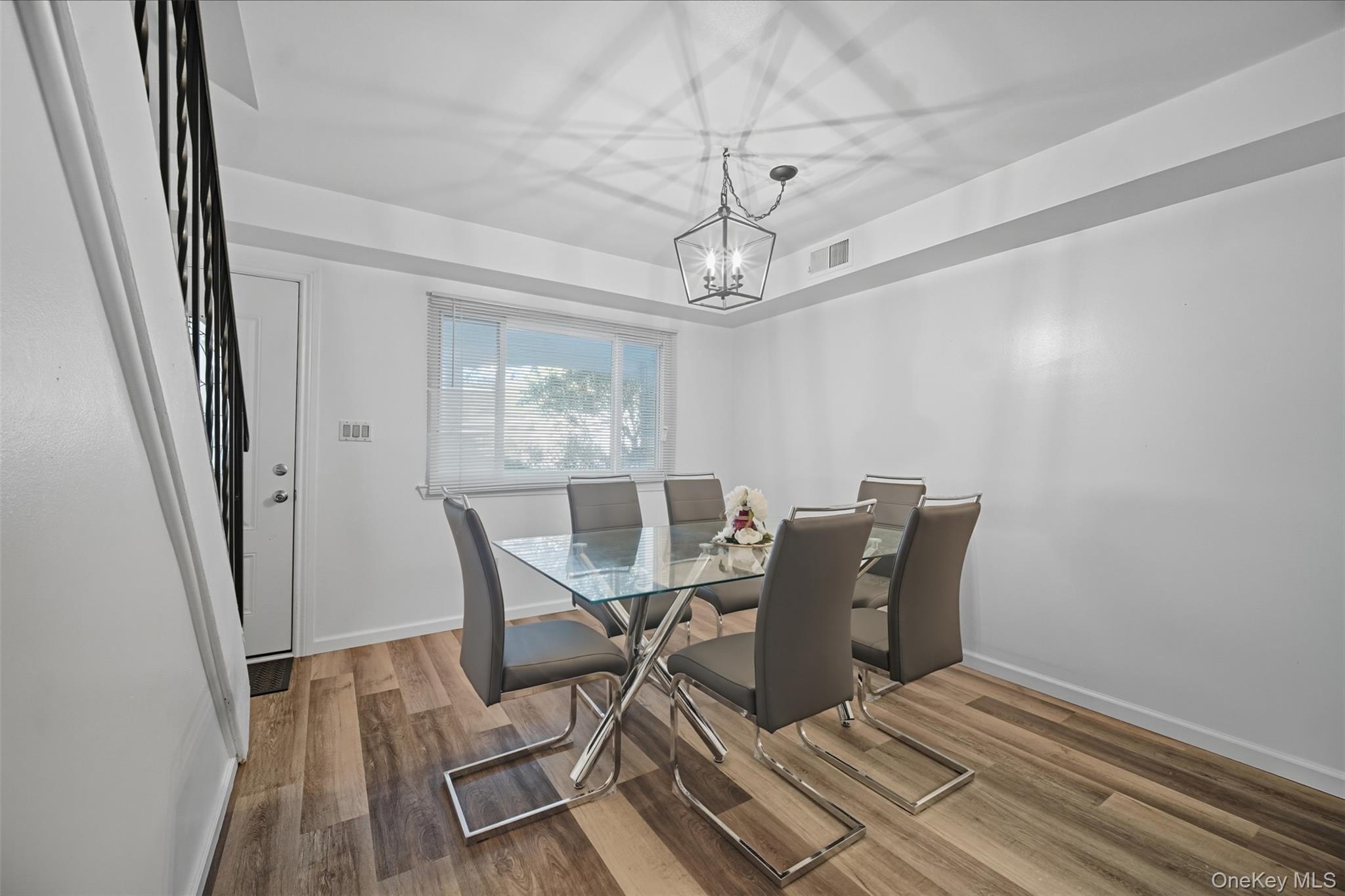 24 Wooded Way Calverton, NY 11933 - Photo 3 of 29 a view of a dining room with furniture wooden floor and chandelier
