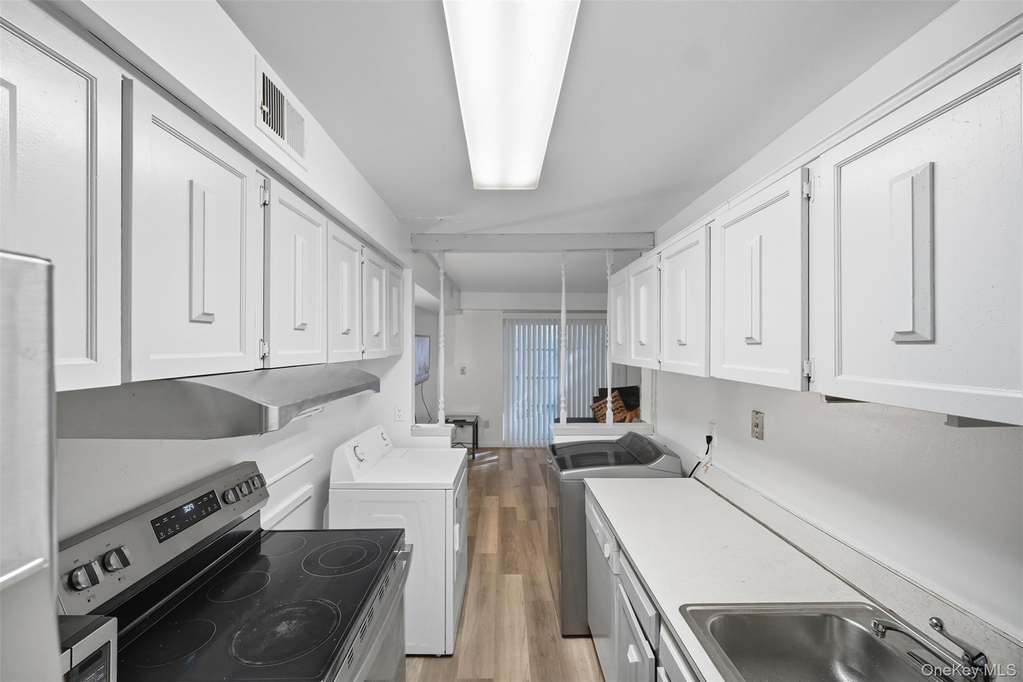 24 Wooded Way Calverton, NY 11933 - Photo 6 of 29 a kitchen with a stove a sink and a refrigerator