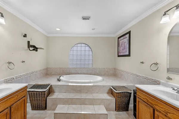 a bathroom with a granite countertop bathtub sink vanity mirror and toilet