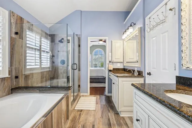 a spacious bathroom with a granite countertop tub sink and mirror