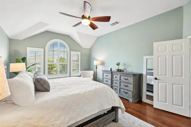 a bedroom with a large bed and a chandelier