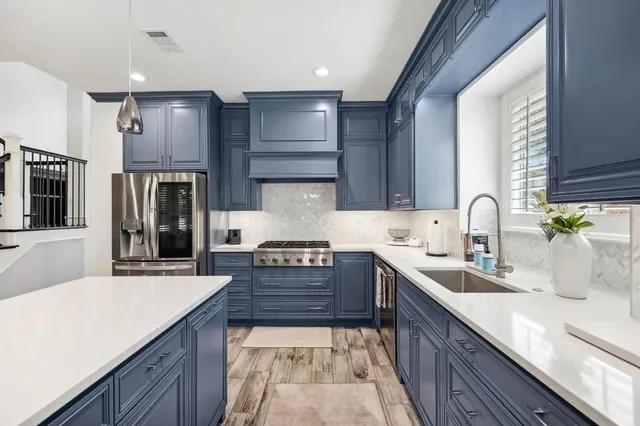 a large kitchen with stainless steel appliances kitchen island granite countertop a sink and cabinets