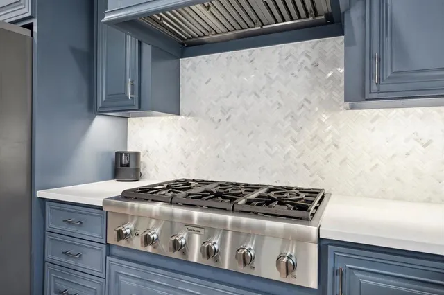 a kitchen with granite countertop a stove and a wooden cabinets