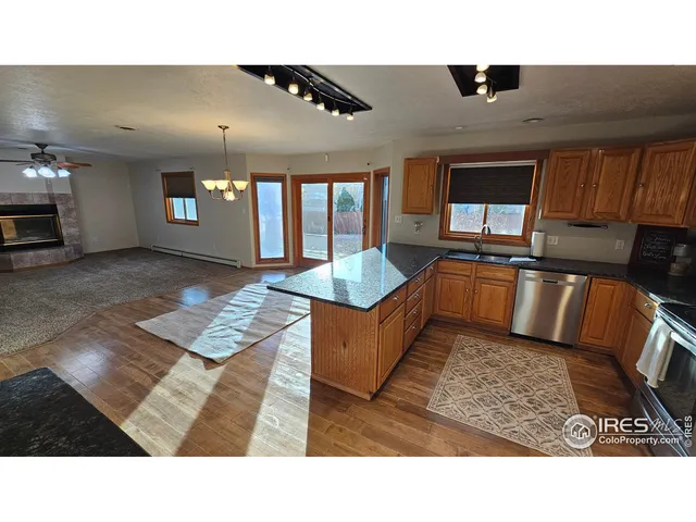 a living room with stainless steel appliances kitchen island granite countertop a sink and cabinets