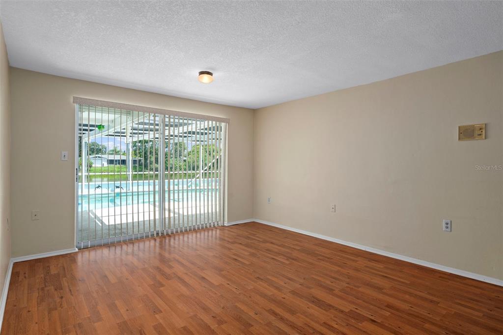 7403 Populus Drive Port Richey, FL 34668 - Photo 13 of 50 a view of an empty room with wooden floor and a window