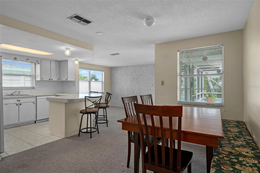 7403 Populus Drive Port Richey, FL 34668 - Photo 17 of 50 a kitchen with kitchen island a dining table chairs and white cabinets