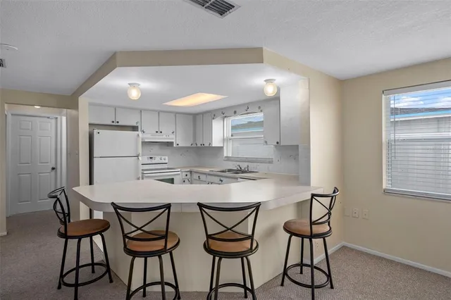 a kitchen with a table chairs sink and cabinets
