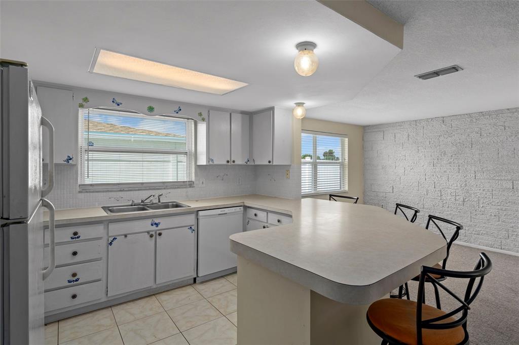 7403 Populus Drive Port Richey, FL 34668 - Photo 23 of 50 a kitchen with a table chairs sink and cabinets