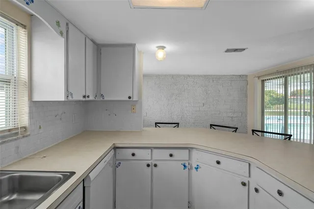 a kitchen with a refrigerator sink stove and cabinets