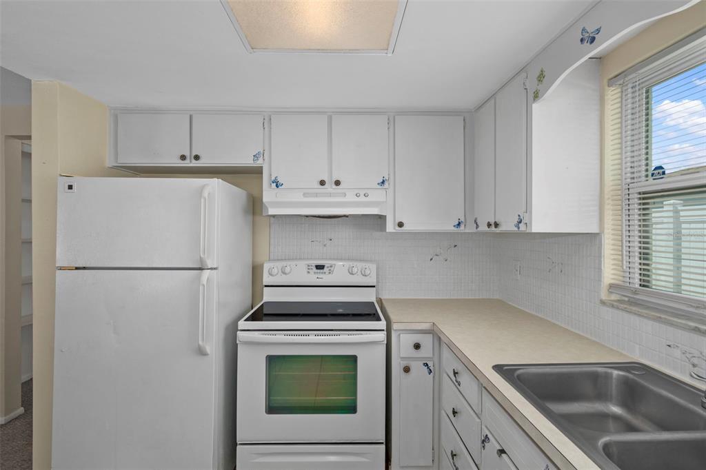 7403 Populus Drive Port Richey, FL 34668 - Photo 25 of 50 a kitchen with a refrigerator sink stove and cabinets