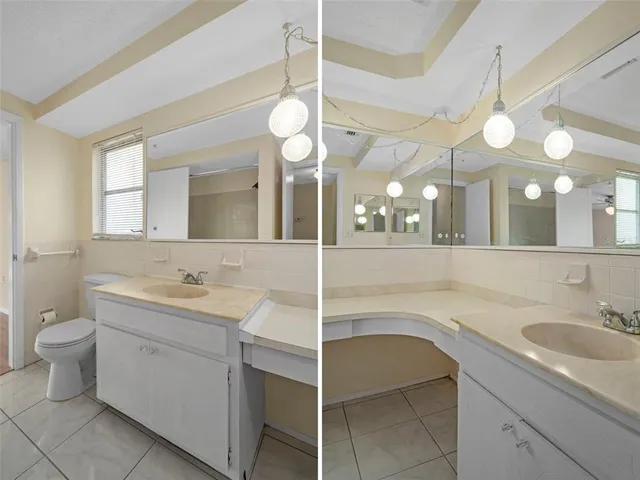 a bathroom with a sink a large mirror and a light fixture
