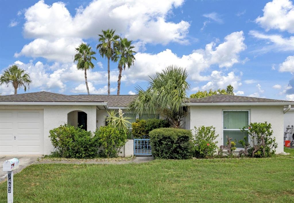 7403 Populus Drive Port Richey, FL 34668 - Photo 6 of 50 a front view of a house with a garden
