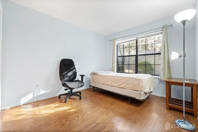 a bedroom with a bed chair and a large window