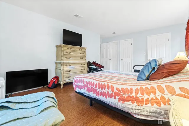 a bedroom with a bed and flat screen tv