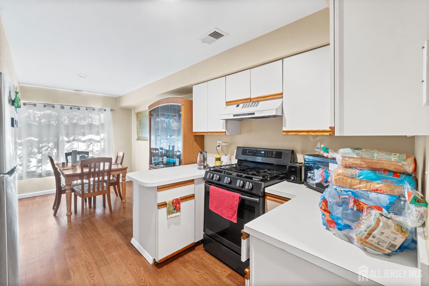 1002 Hidden Village Drive Perth Amboy, NJ 08861 - Photo 5 of 18 a kitchen that has a lot of cabinets a sink and appliances in it