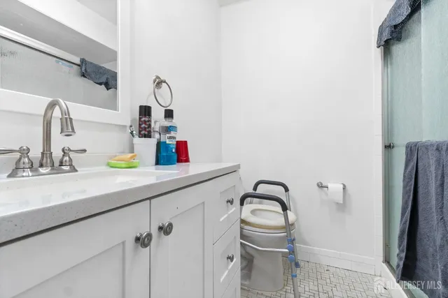 a bathroom with a sink vanity granite and a mirror