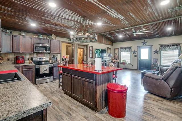a kitchen with stainless steel appliances granite countertop a sink dishwasher and wooden cabinets with a granite countertops