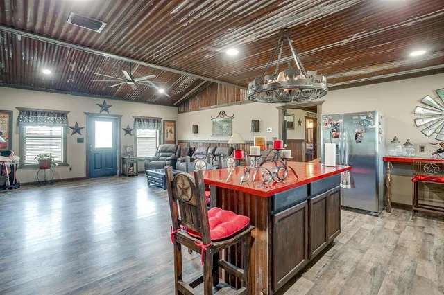 a living room with stainless steel appliances kitchen island granite countertop lots of wooden furniture
