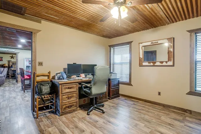 a view of a workspace with furniture and a window