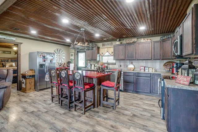a kitchen with granite countertop a sink cabinets and stainless steel appliances