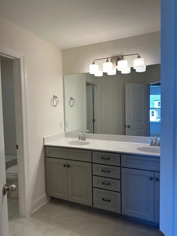 a bathroom with a double vanity sink and a mirror