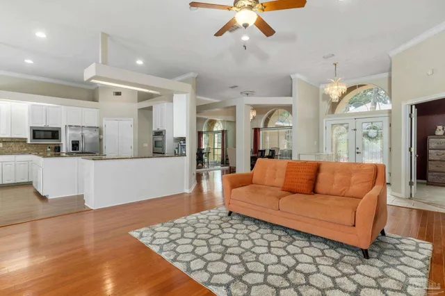 a view of a dining room with furniture a chandelier and wooden floor