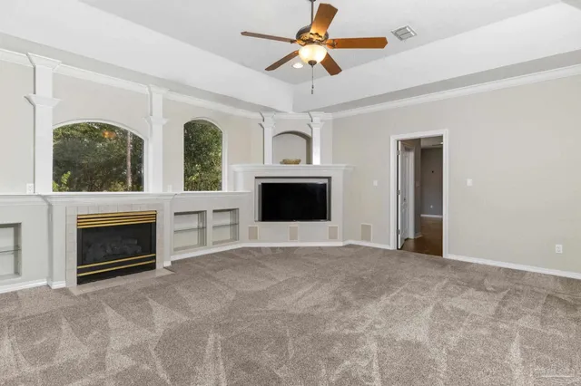 a view of a room with wooden floor and a ceiling fan
