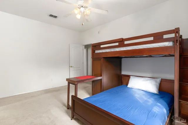 an empty room with closet and a chandelier fan